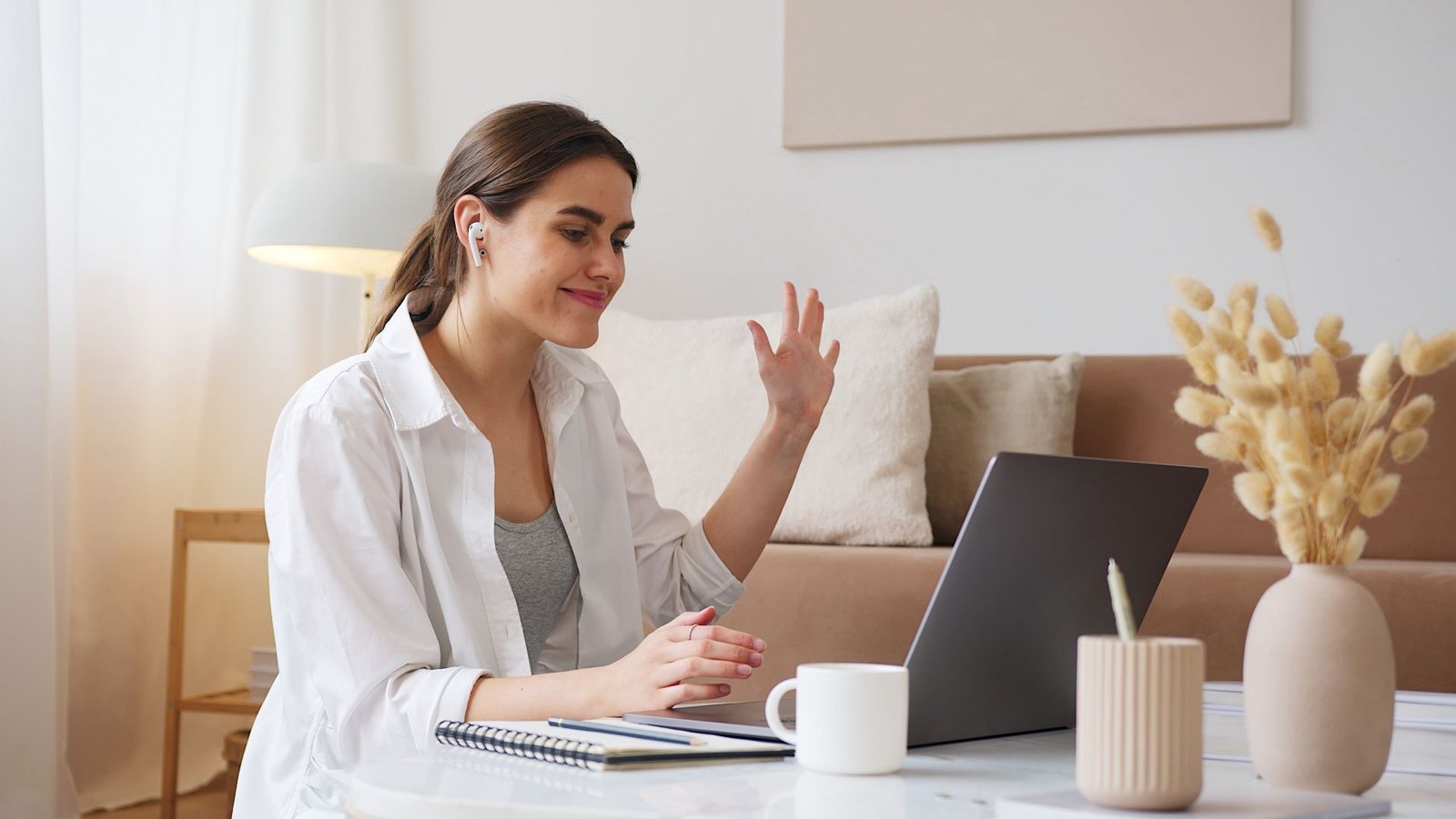 Cheerful woman on a video call with her laptop in a cozy living room