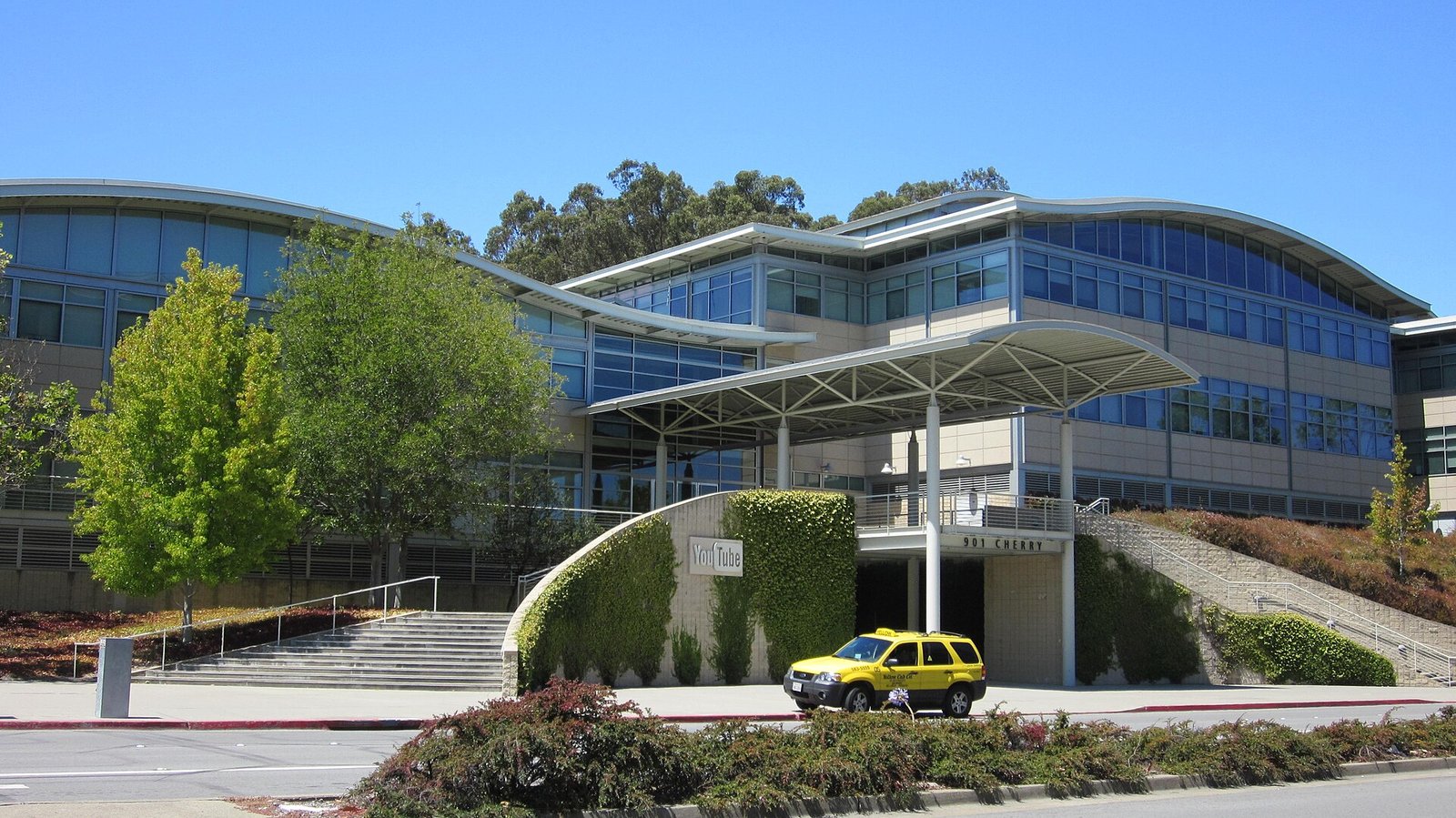 YouTube headquarters building with the YouTube sign visible on the wall under a blue sky