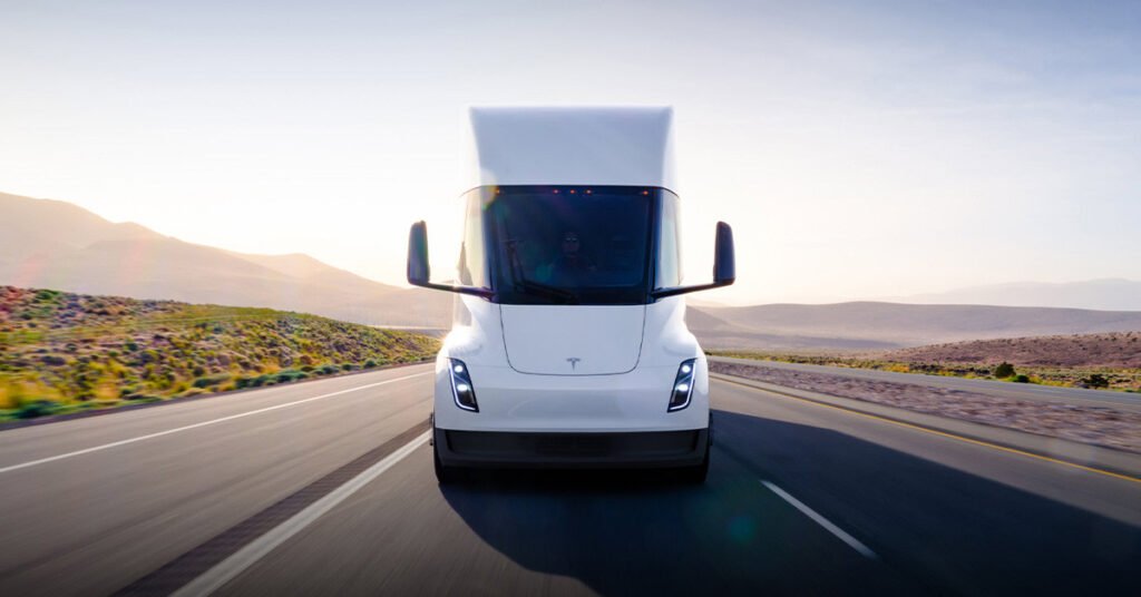 White Tesla Semi electric truck driving on a desert highway at sunset