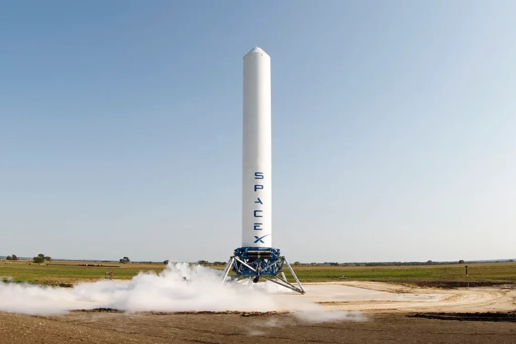 A rocket standing vertical on its launch pad against a dramatic sky