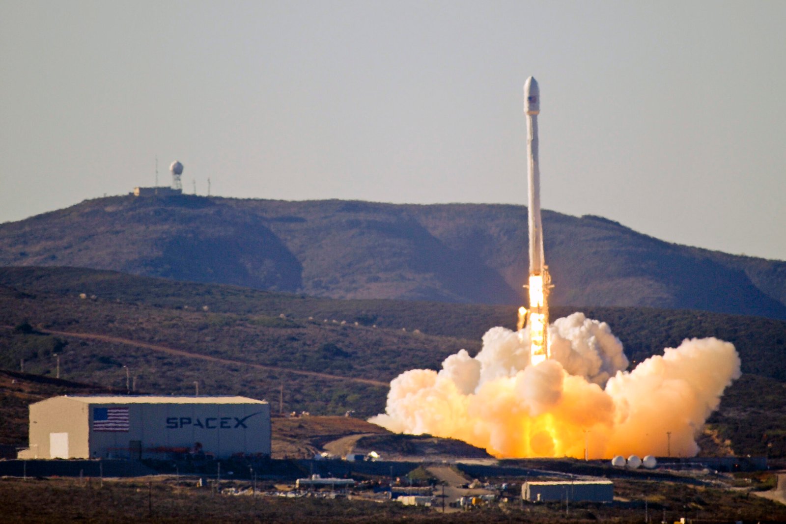 A SpaceX Falcon 9 rocket lifts off from Vandenberg Space Force Base in California, trailing bright flame and smoke plumes