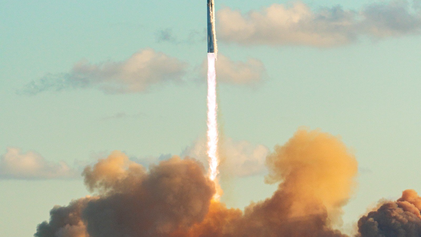 SpaceX Starship lifting off with a bright exhaust plume