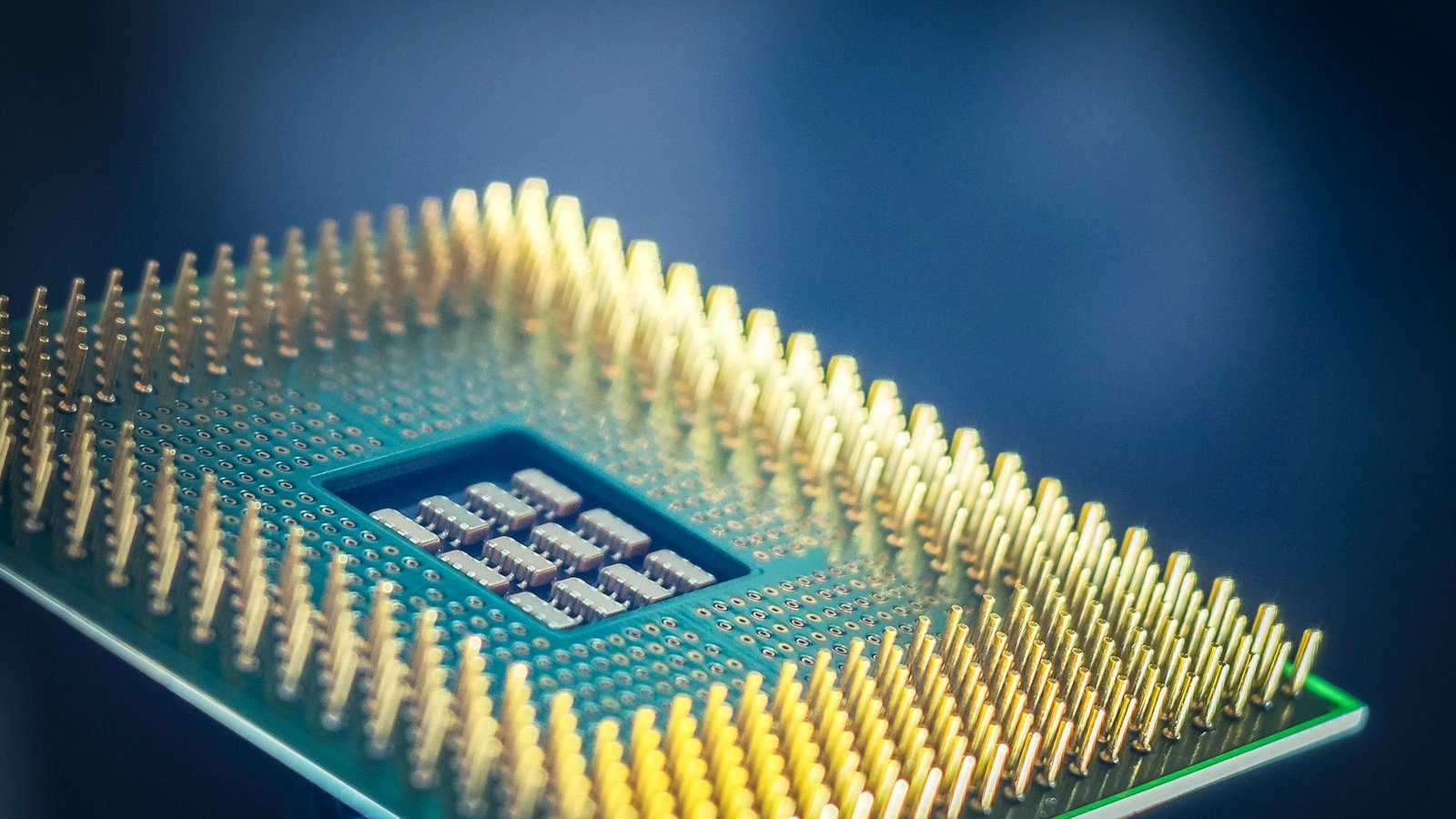 Close-up macro photograph of a computer processor with golden pins on a dark background