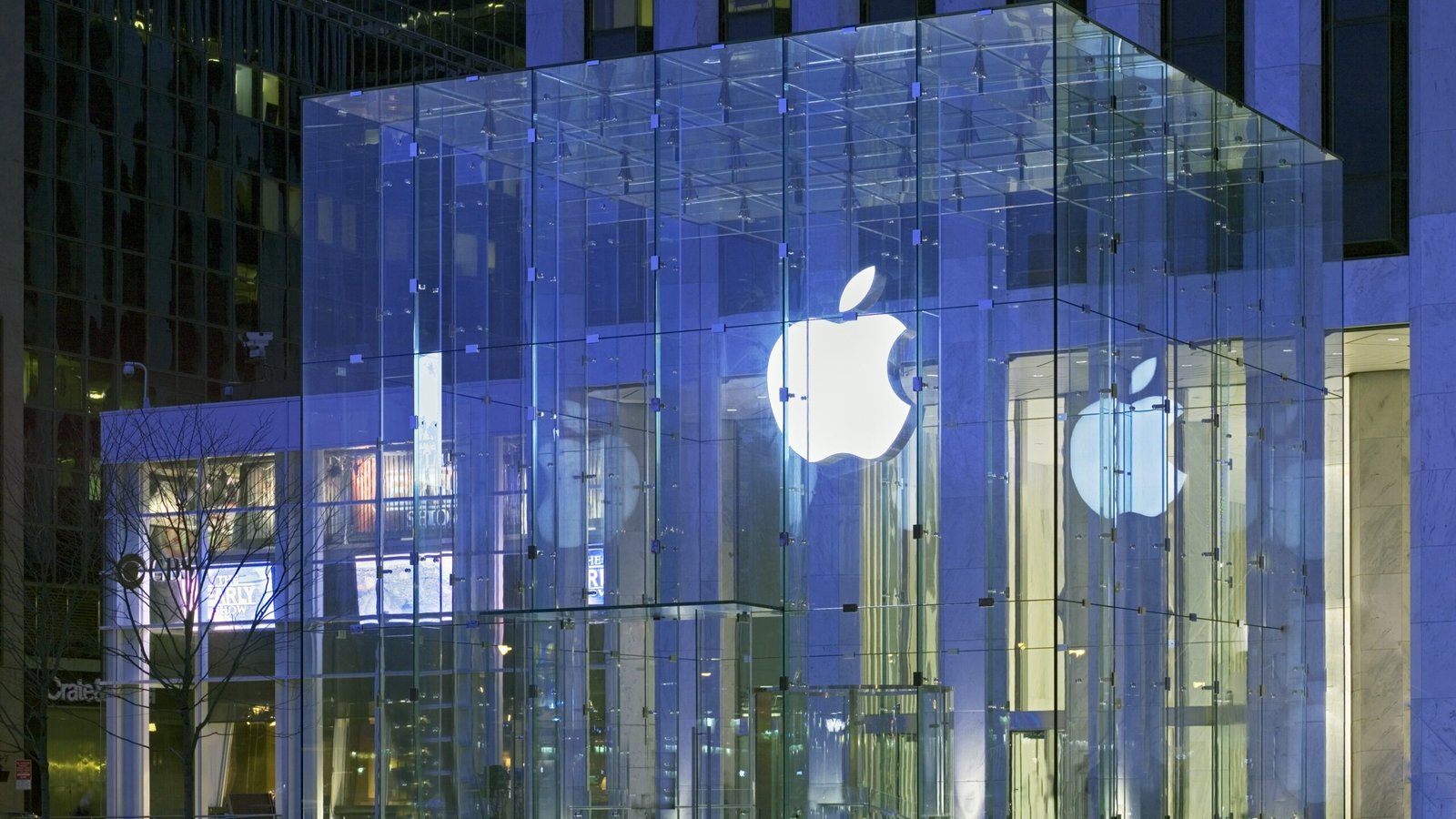 Apple Store glass cube glowing at night on Fifth Avenue in New York