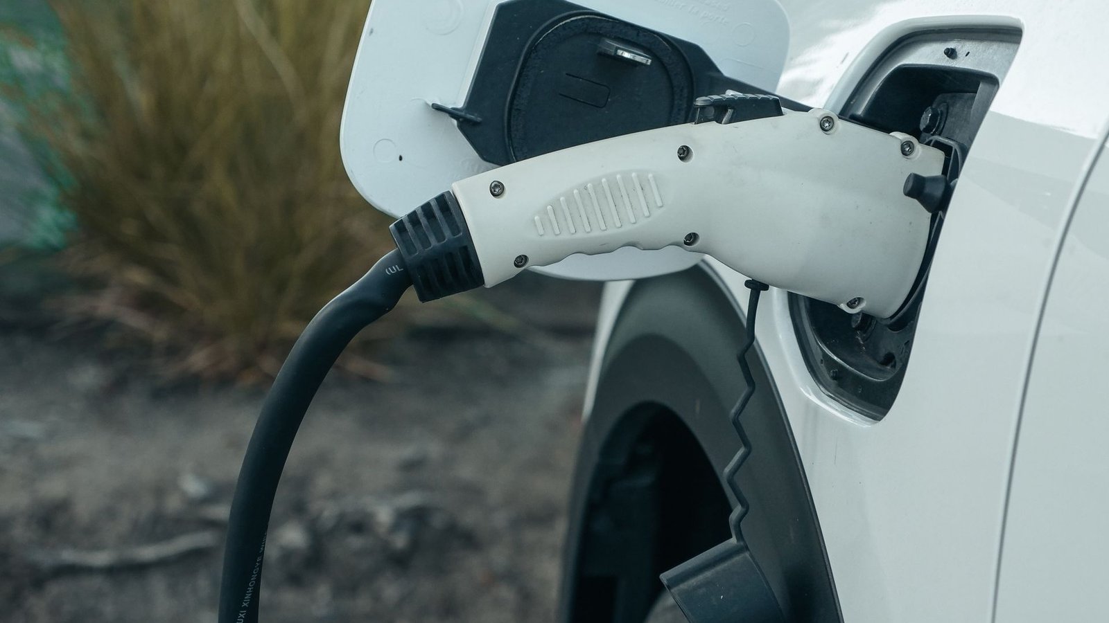 EV charge plug connected to a car at a fast-charging station