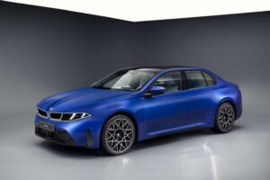 Blue 2027 BMW i3 50 xDrive electric sedan in a studio, front three-quarter view