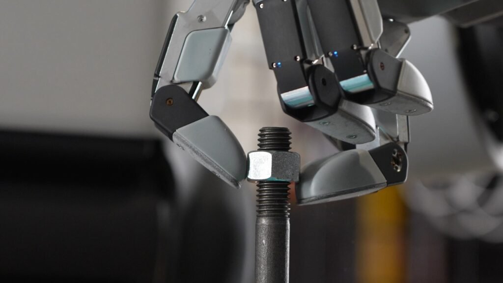 Close-up of Boston Dynamics' new four-finger Atlas robot hand tightening a nut on a bolt