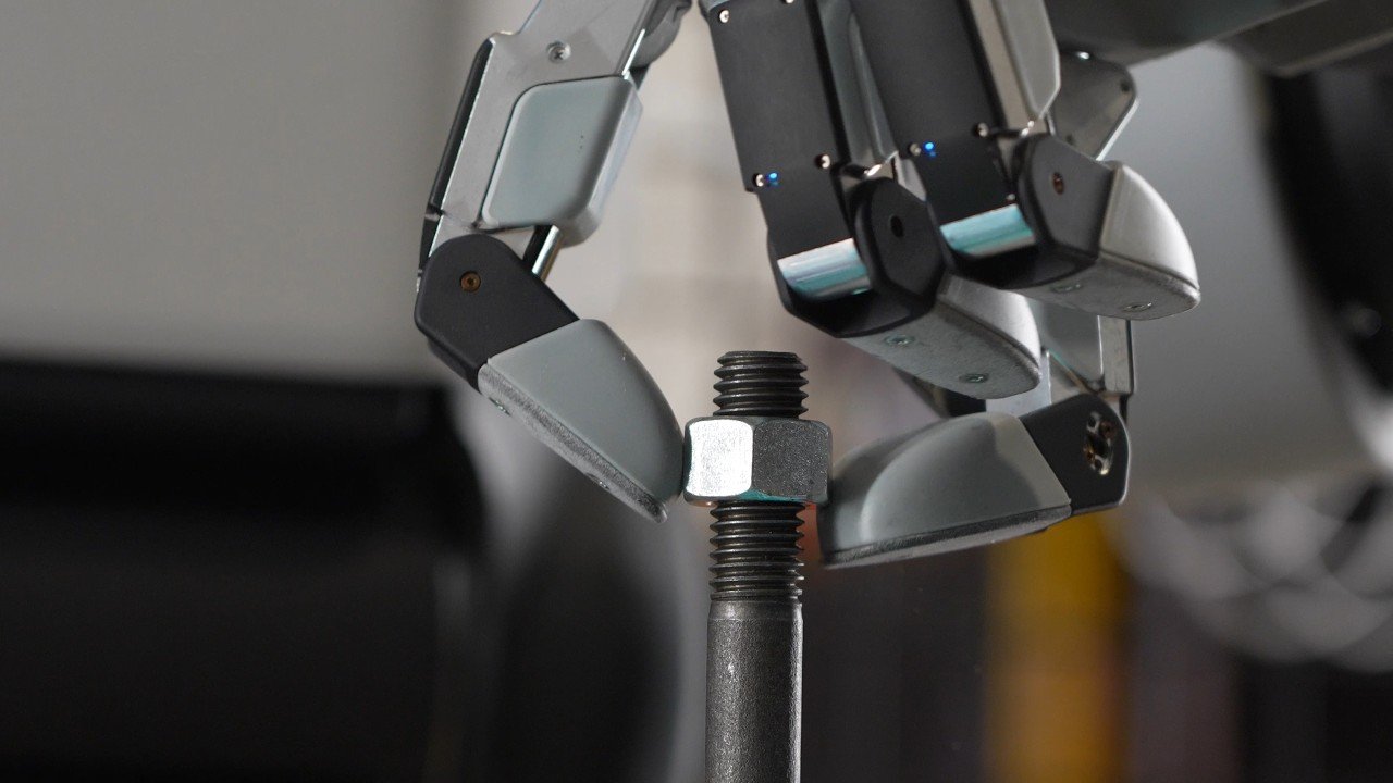 Close-up of Boston Dynamics' new four-finger Atlas robot hand tightening a nut on a bolt
