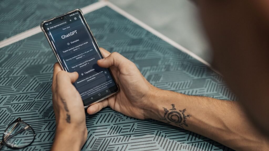 Hands holding a smartphone showing the ChatGPT app on screen