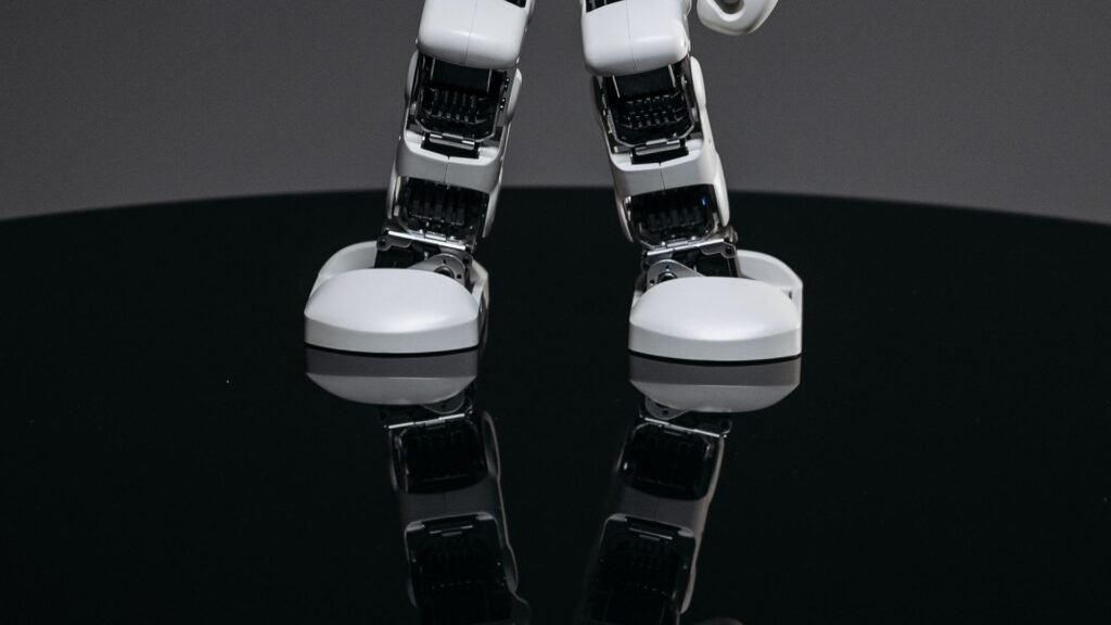 Close-up of a small white humanoid robot on a dark surface