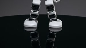 Close-up of a small white humanoid robot on a dark surface