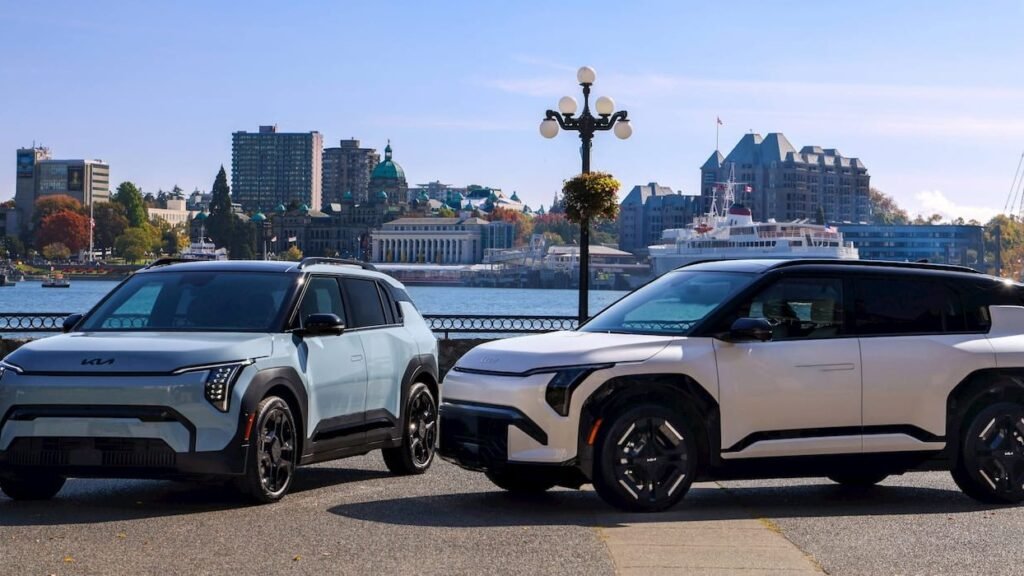 Two Kia EV3 electric SUVs parked by a waterfront under a bright blue sky