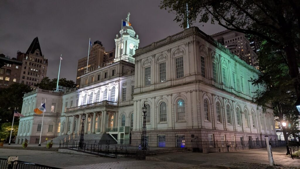 New York City Hall illuminated at night under a dark sky