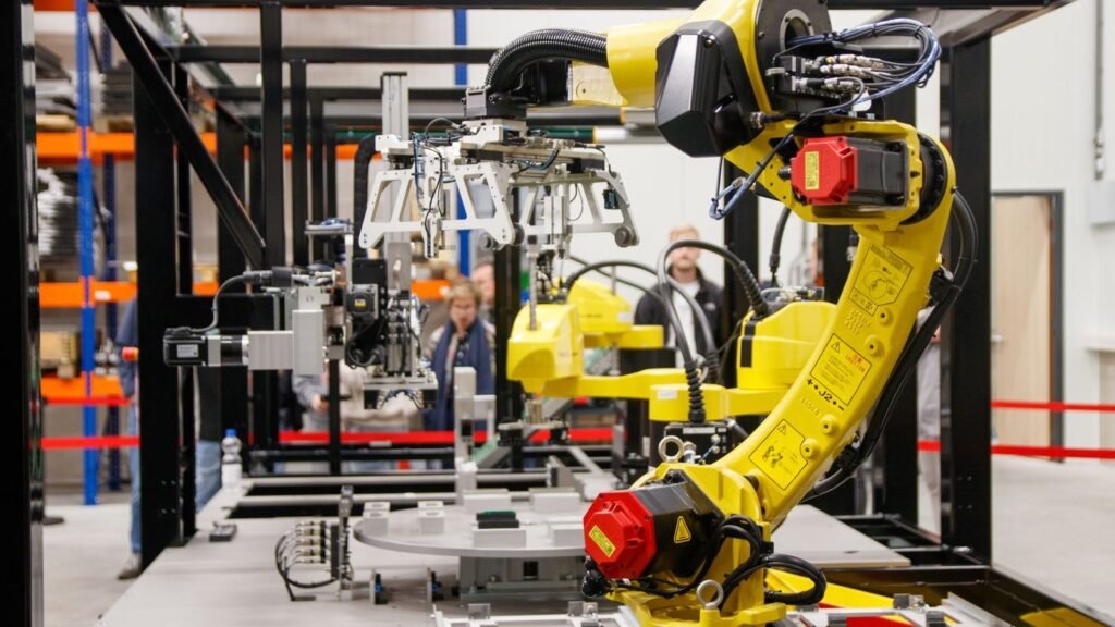 A yellow industrial robotic arm working inside an automated factory cell