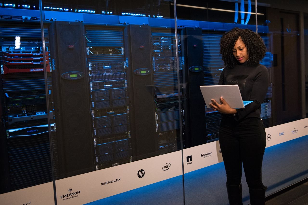 Engineer monitoring server racks and network activity in a dark data center control room