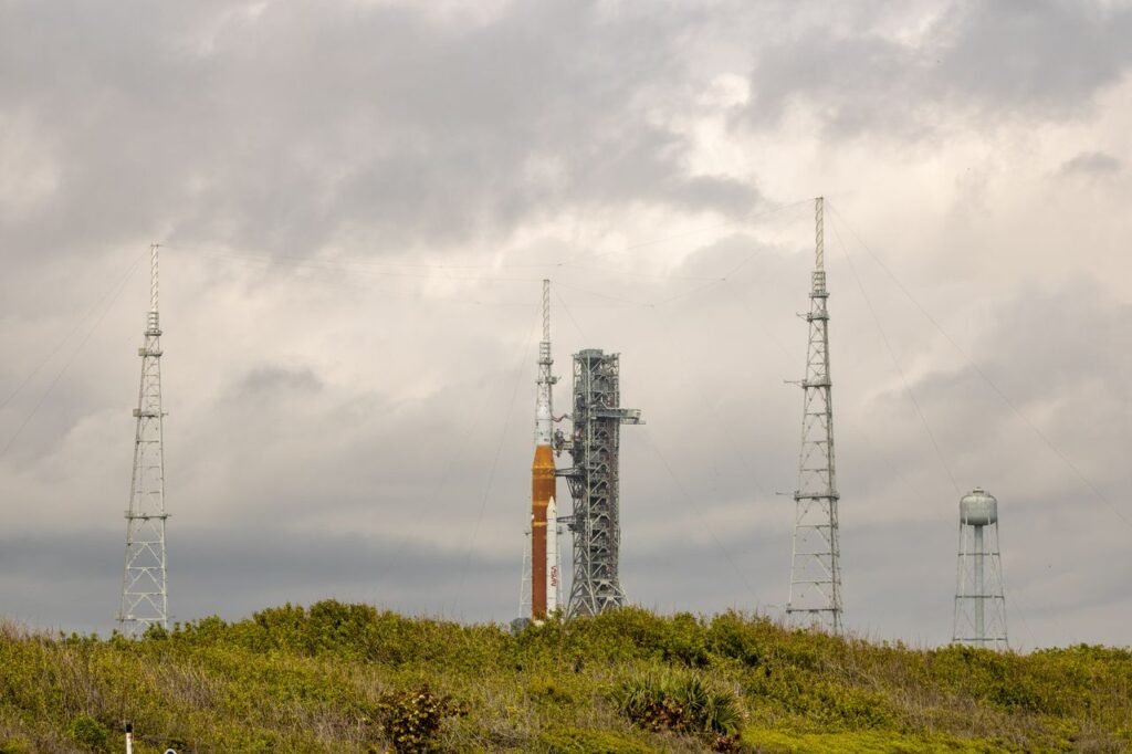 NASA SLS rocket on the launch pad at Kennedy Space Center under a dramatic sky