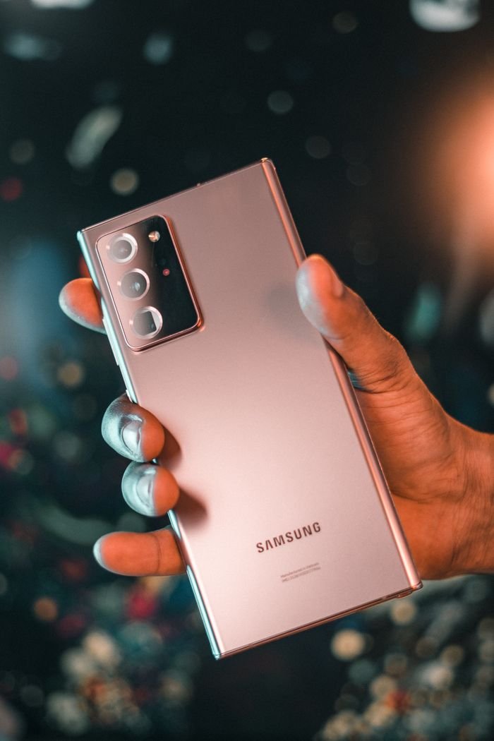 Shopper holding a Samsung Galaxy smartphone in a bright retail store