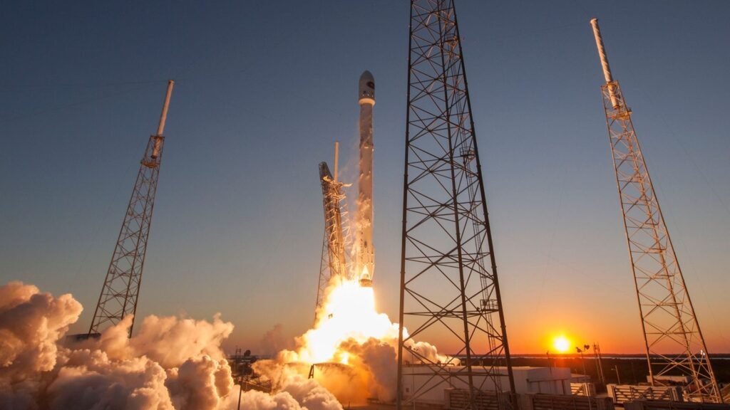 Falcon 9 rocket lifting off at sunset from launch towers at Cape Canaveral