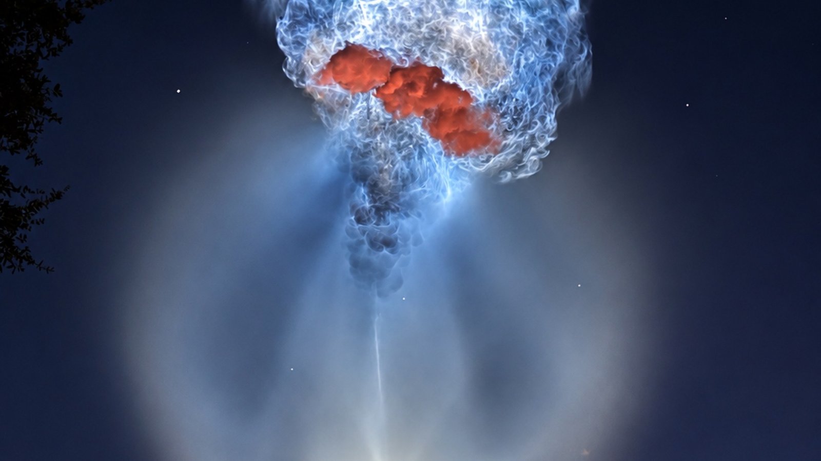 Falcon 9 exhaust plume glowing like a jellyfish in the predawn sky over Cape Canaveral after liftoff