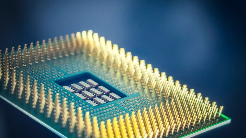 Dramatic macro close-up of a microprocessor's golden contact pins against a deep-blue background