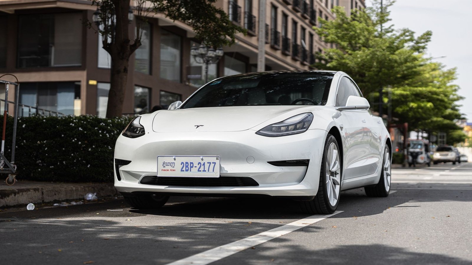 White Tesla Model 3 electric sedan parked on a city street