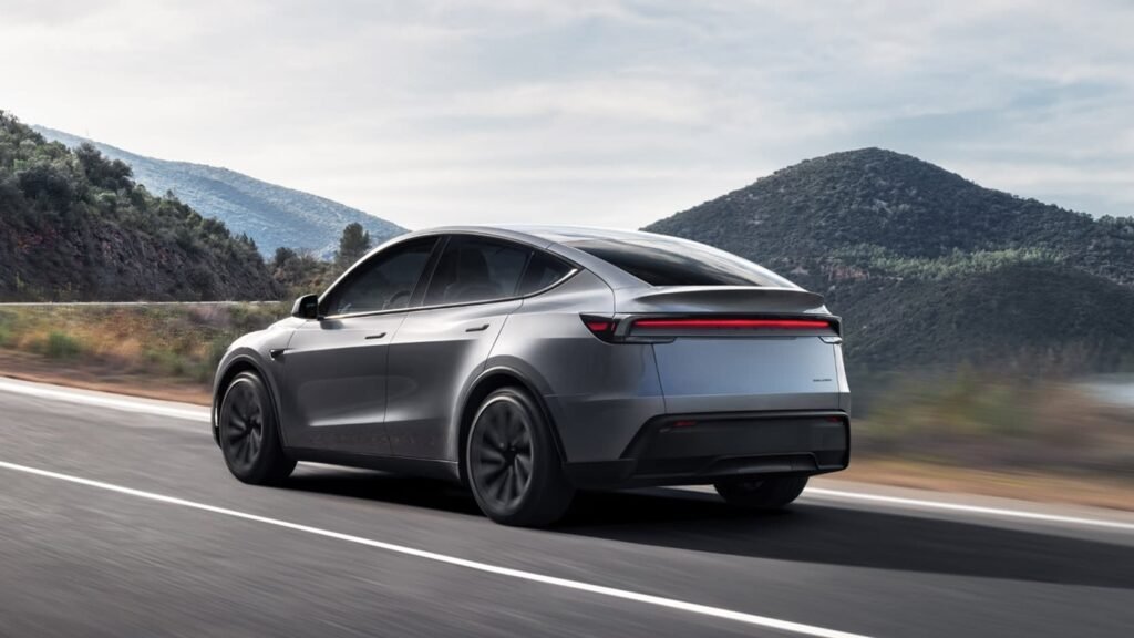 Silver Tesla Model Y driving on a winding mountain road