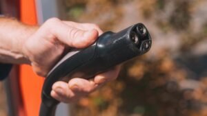 Hand holding an electric vehicle charging plug close-up