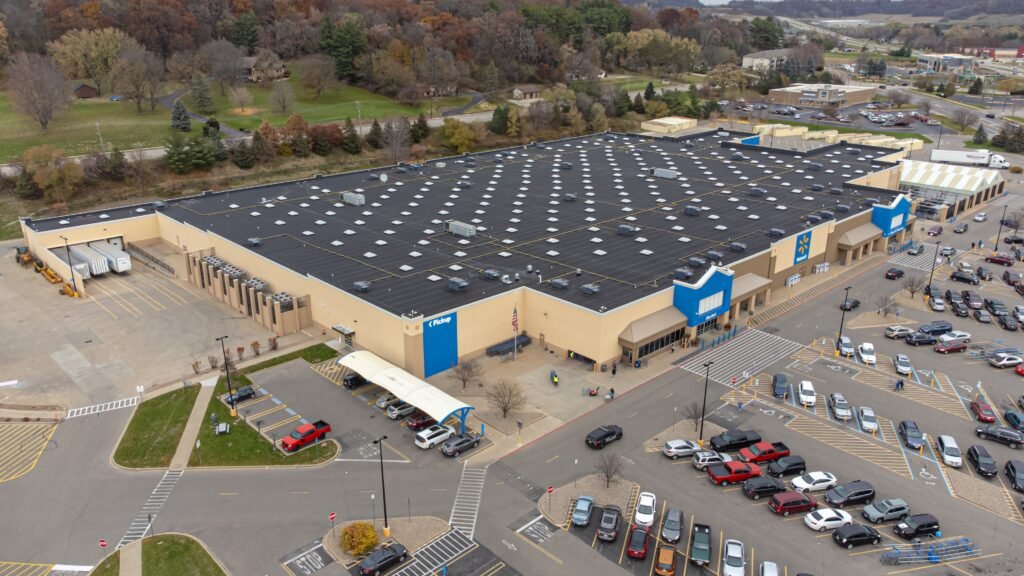 Aerial view of a Walmart store with blue entrance signage, pickup bay, and full parking lot