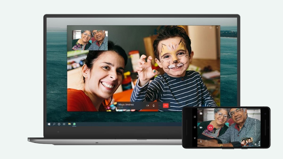 Laptop and phone showing a WhatsApp video call with a family on screen